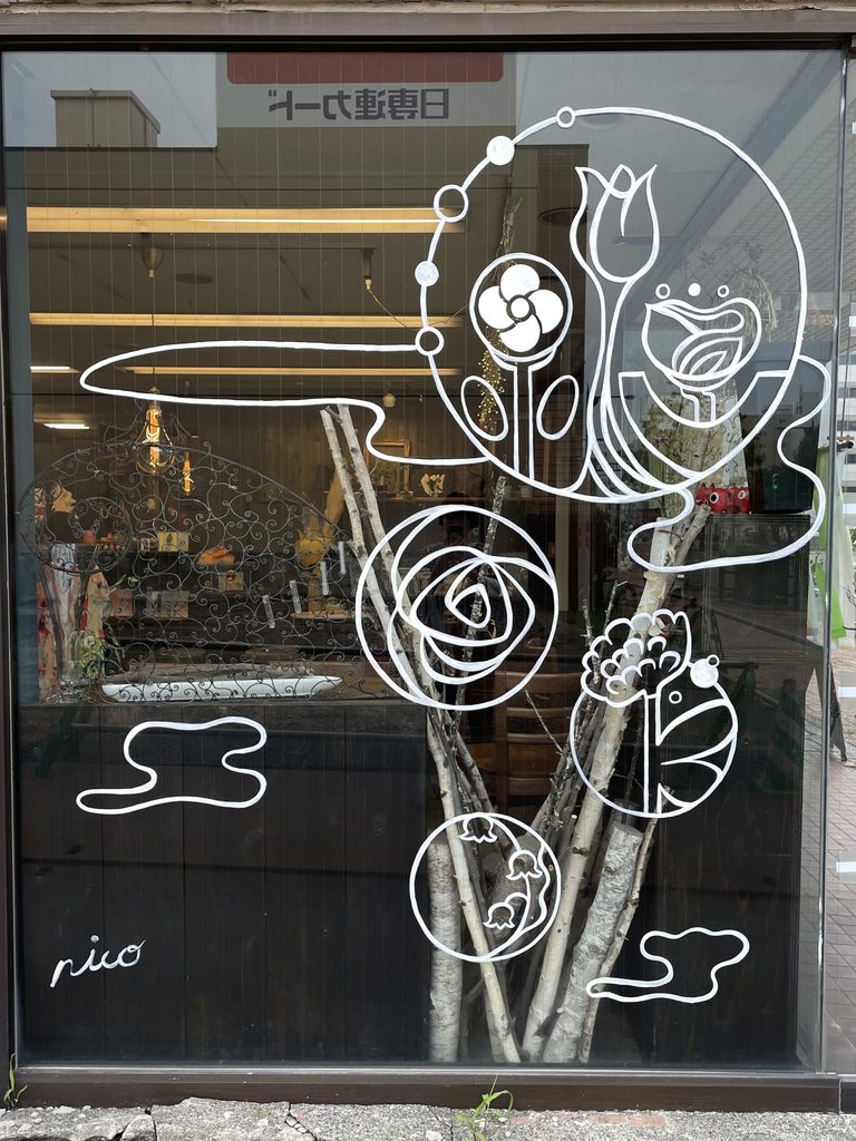 苫小牧の店舗の大きなガラス面に白い線画を描いたnicoのライブペイント